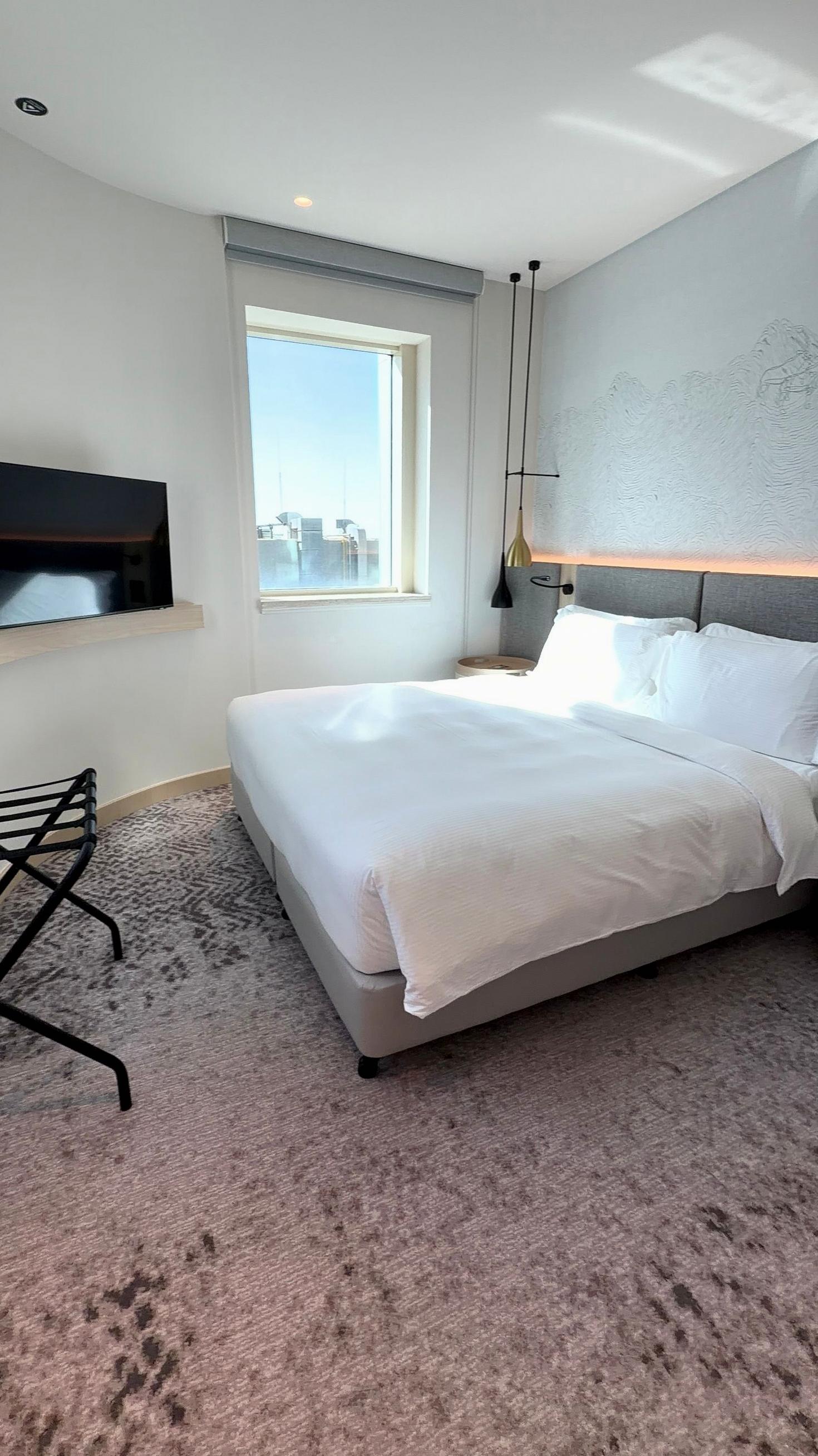 Minimalist urban hotel room with large window overlooking Amsterdam